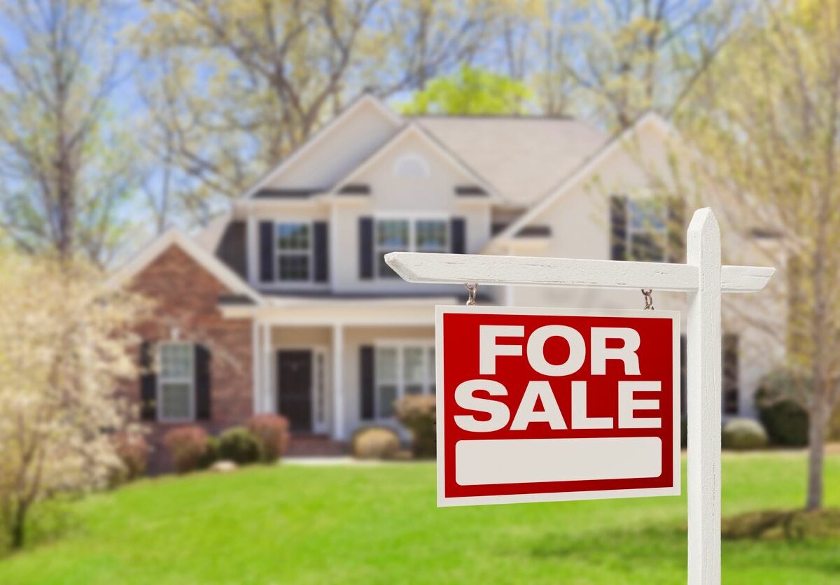 A for sale sign posted in front of a house