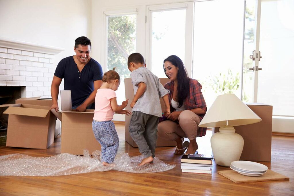 A family packing while their kids step on the bubble wrap 