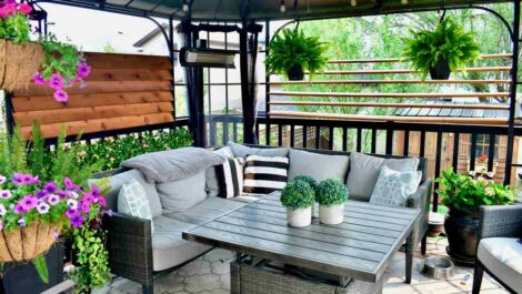 A patio with string lights, plants, and nice summer furniture.