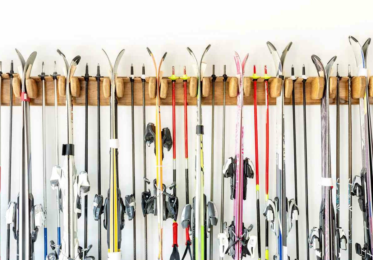 Many sets of skis organized neatly on a hanging rack