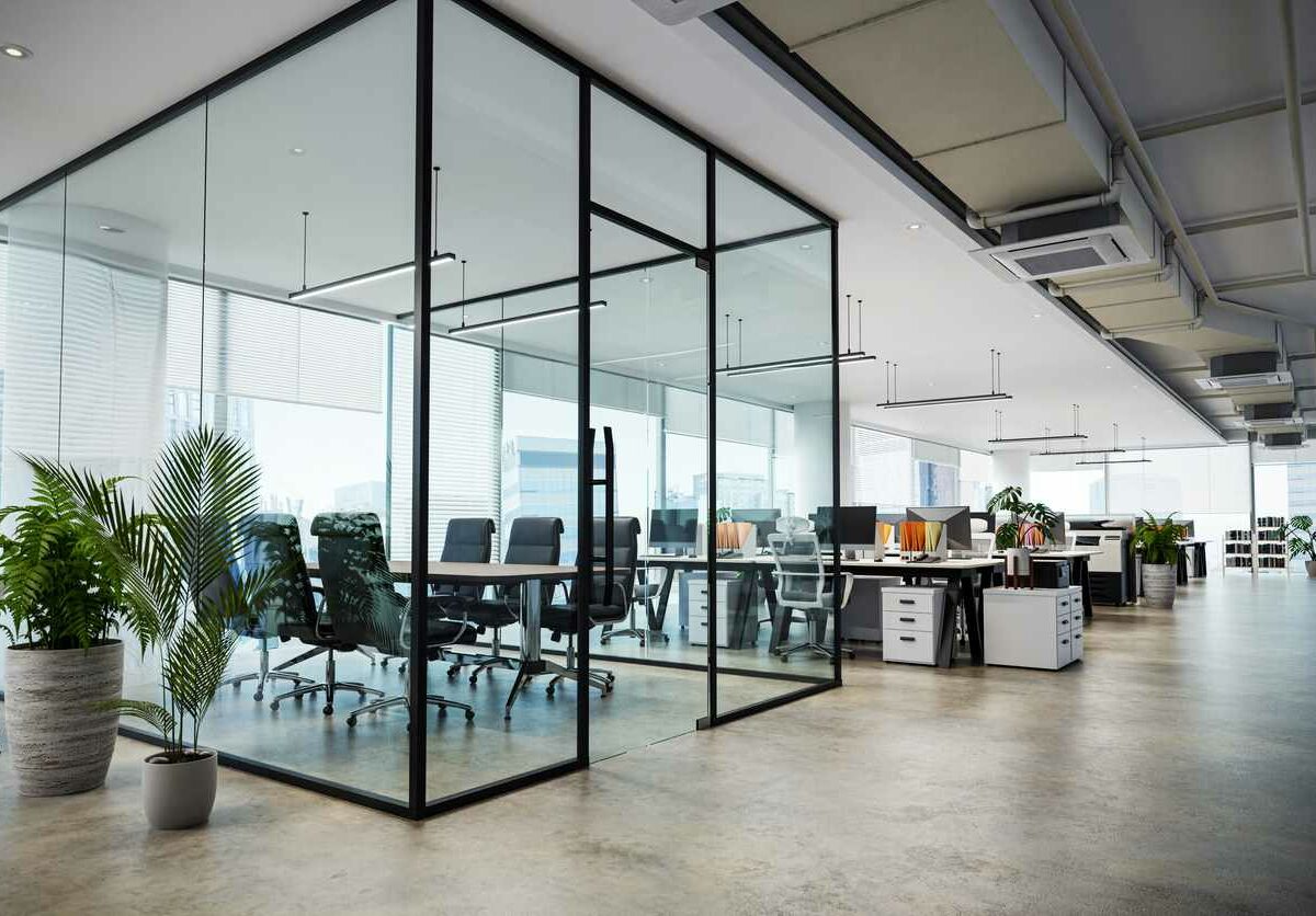 A glass conference room in a modern office surrounded by modern furniture