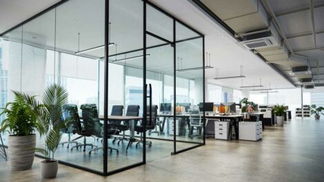 A glass conference room in a modern office surrounded by modern furniture