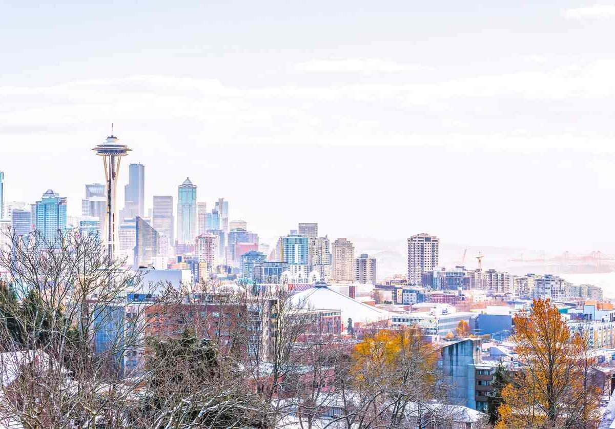 An image of the Seattle skyline in the winter, with snow on buildings and the space needle in the horizon